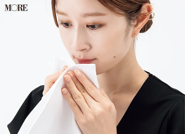 マナーブック冠婚葬祭食事編　【基本のテーブルマナー】和食・洋食の正しい振る舞いを解説。ナプキンで口を拭こうとしている女性の写真