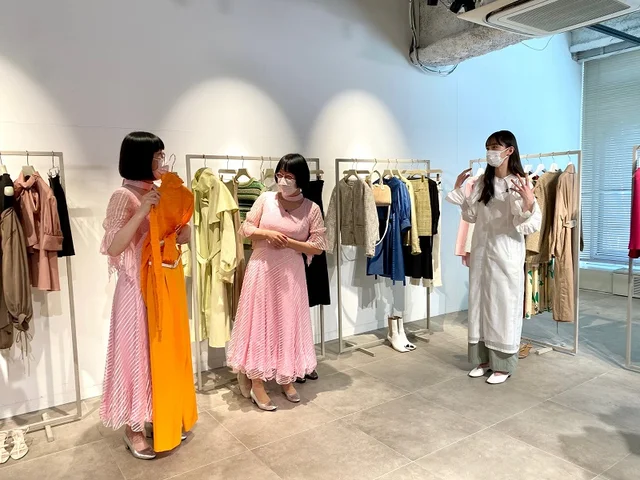 ビタミンカラーのオレンジコーデを阿佐ヶ谷姉妹が見ている様子。右の脇には井桁弘恵