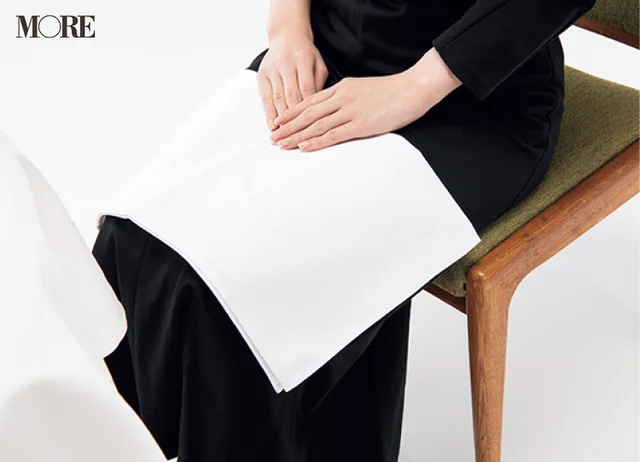 マナーブック冠婚葬祭食事編　【基本のテーブルマナー】和食・洋食の正しい振る舞いを解説。ナプキンを膝にかけている女性の写真