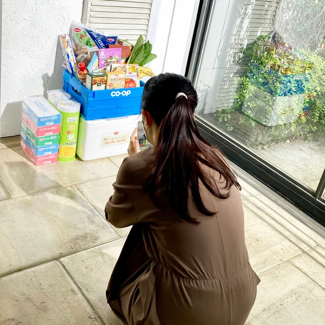 ハウススタジオで、荷物のお届け風シーンの構図を考え中のCOOPのTwitterの中の人。