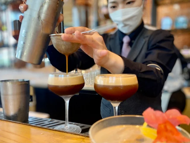 『ロースタリー 東京』2022夏メニュー。バーテンダーがカクテルを作っている様子