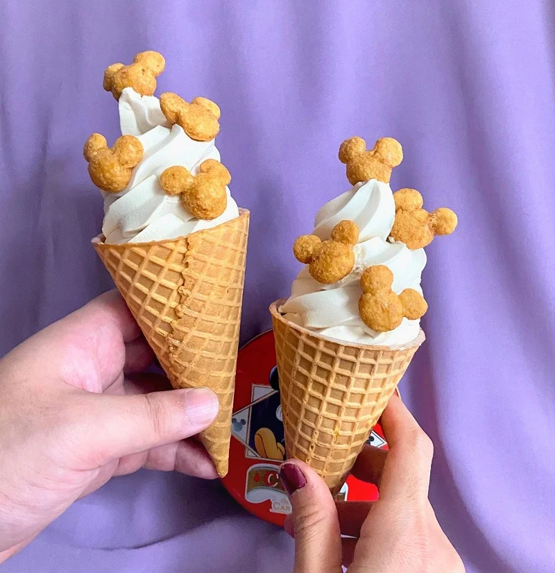 「Disney SWEETS COLLECTION by 東京ばな奈」の新商品「ミッキーマウス/コーン キャラメル味」を市販のソフトクリームにトッピングした様子