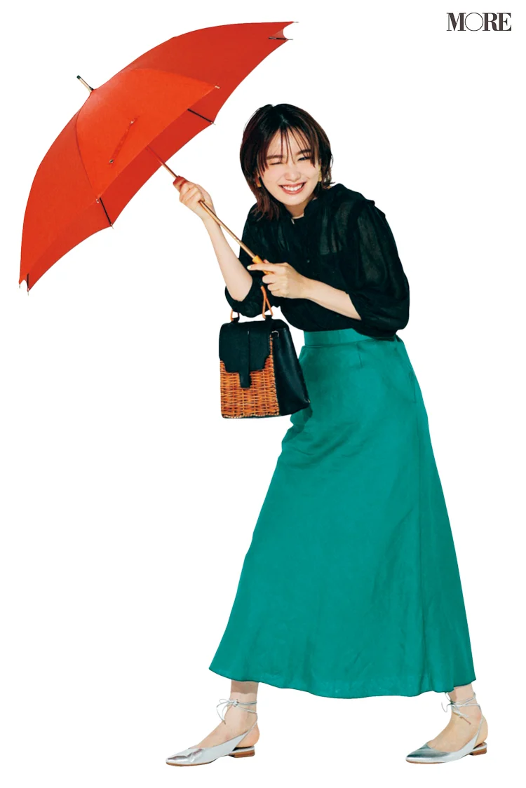 黒ブラウス×グリーンのスカートコーデで傘をさした飯豊まりえ