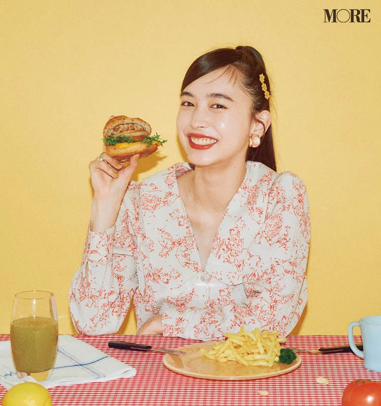 井桁弘恵がビーガンフードのハンバーガーを手に持ちカメラ目線で微笑んでいる様子