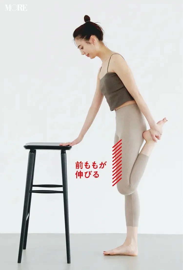 森拓郎ストレッチ法で立ったまま椅子に手をついて前ももが伸びるように片足を折るモデル