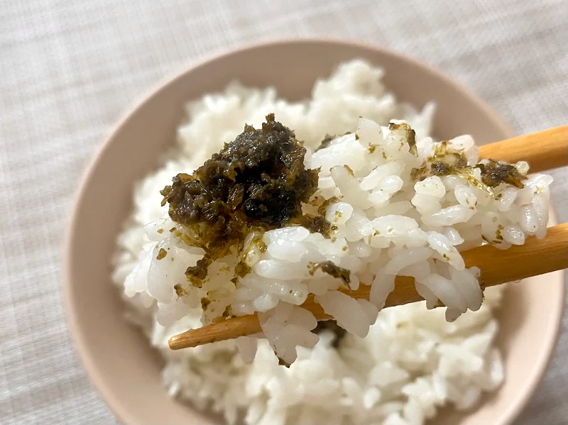 白米に盛り付けた島根県「奥出雲山椒ジャコのり 頼むからごはんください。」をお箸でつまんでいる様子