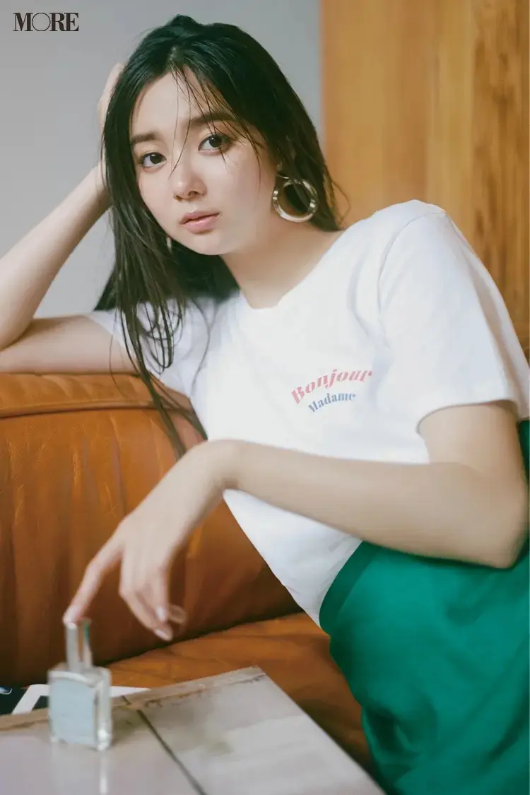 白いロゴTシャツ×グリーンのスカートコーデの新川優愛