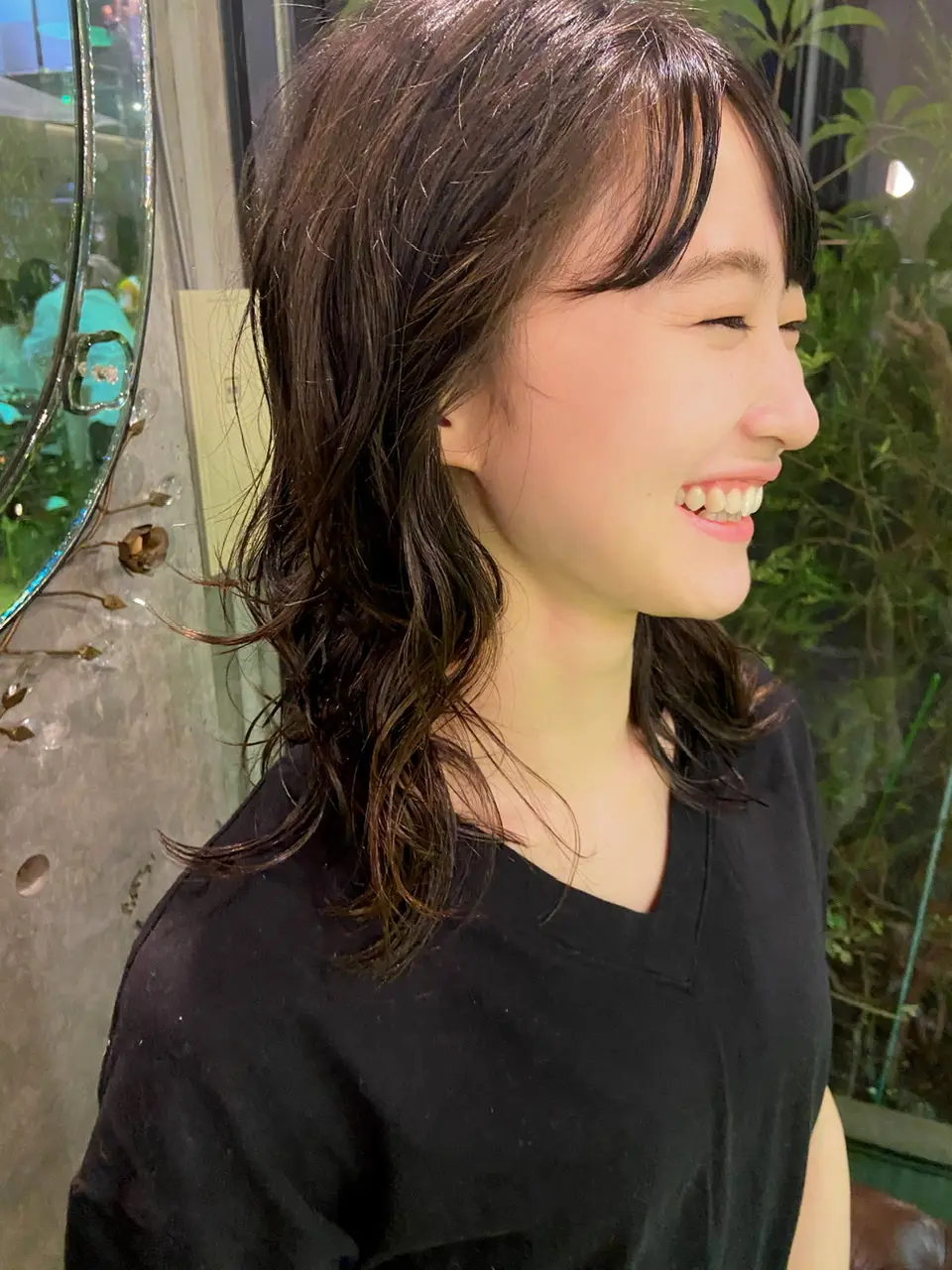 レイヤーカットにパーマをかけた女性の写真
