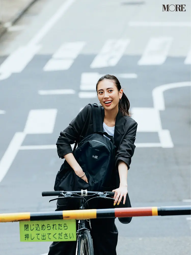 黒リュックを持って自転車に乗る土屋巴瑞季