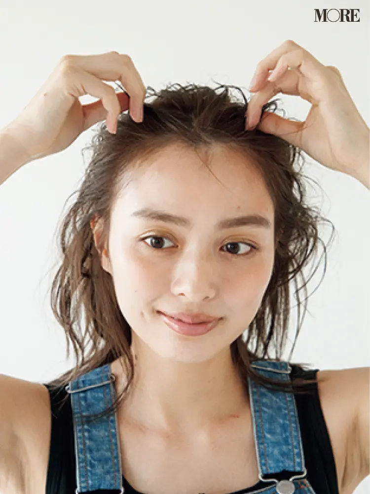 梅雨のおだんごヘアアレンジでワックスを髪の根本につける女性