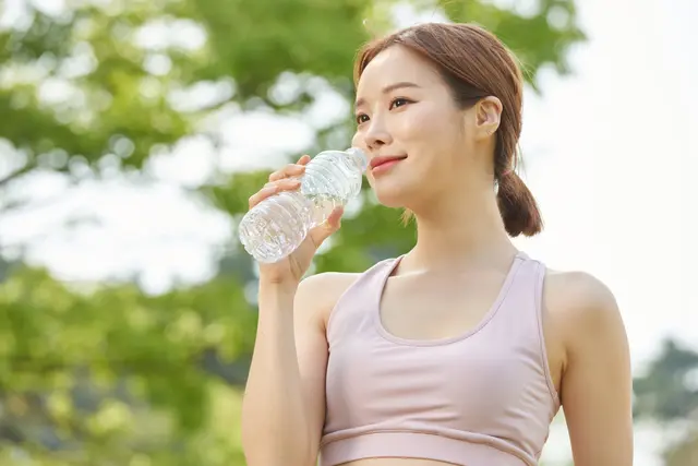 スポーツブラを着用した女性が水を飲んでいる様子
