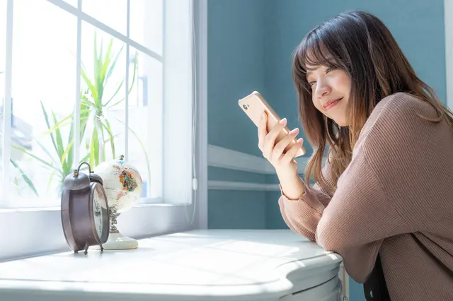 椅子に座りスマホを操作する女性
