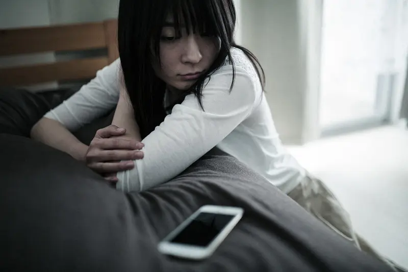 恋人からの連絡を待っている女性のイメージ画像