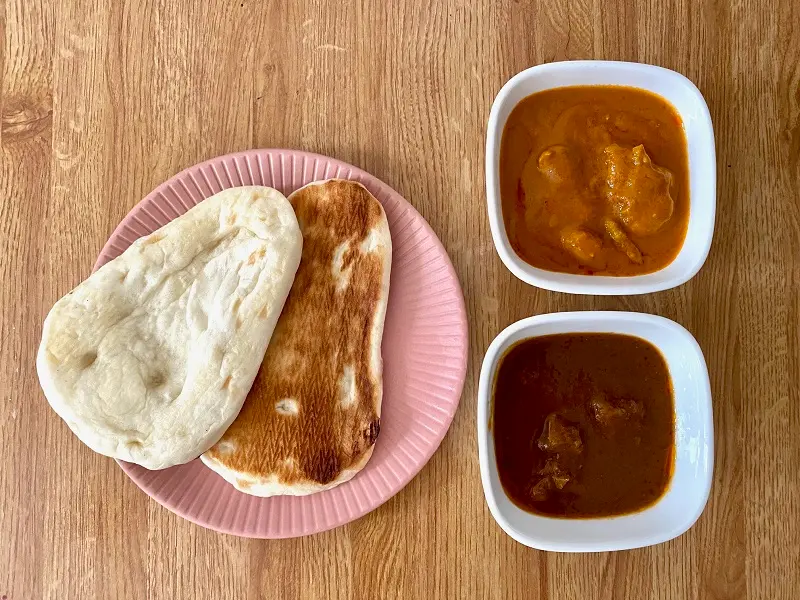 おすすめコンビニご飯【セブン₋イレブン】の「ミニナン」をお皿に並べ、隣に2種類のカレーを並べた様子