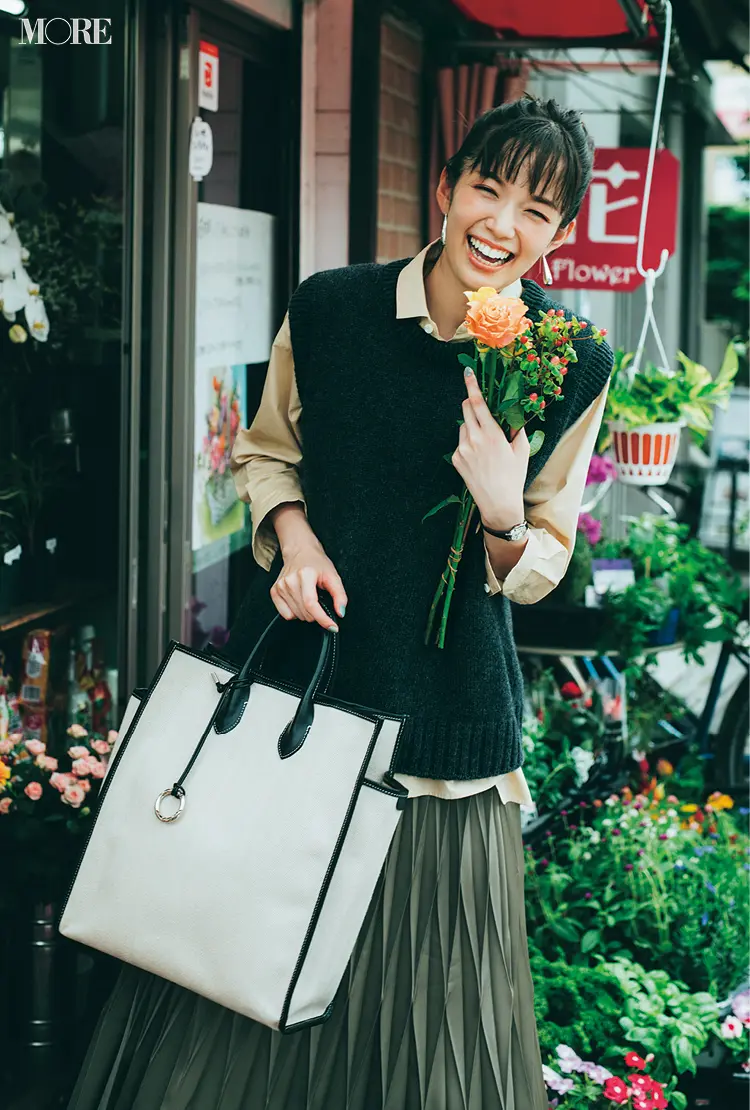 シャツとニットベストのレイヤードにプリーツスカートを合わせた佐藤栞里