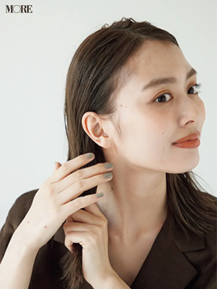梅雨のシンプルバレッタヘアアレンジでヘアオイルを髪につける女性
