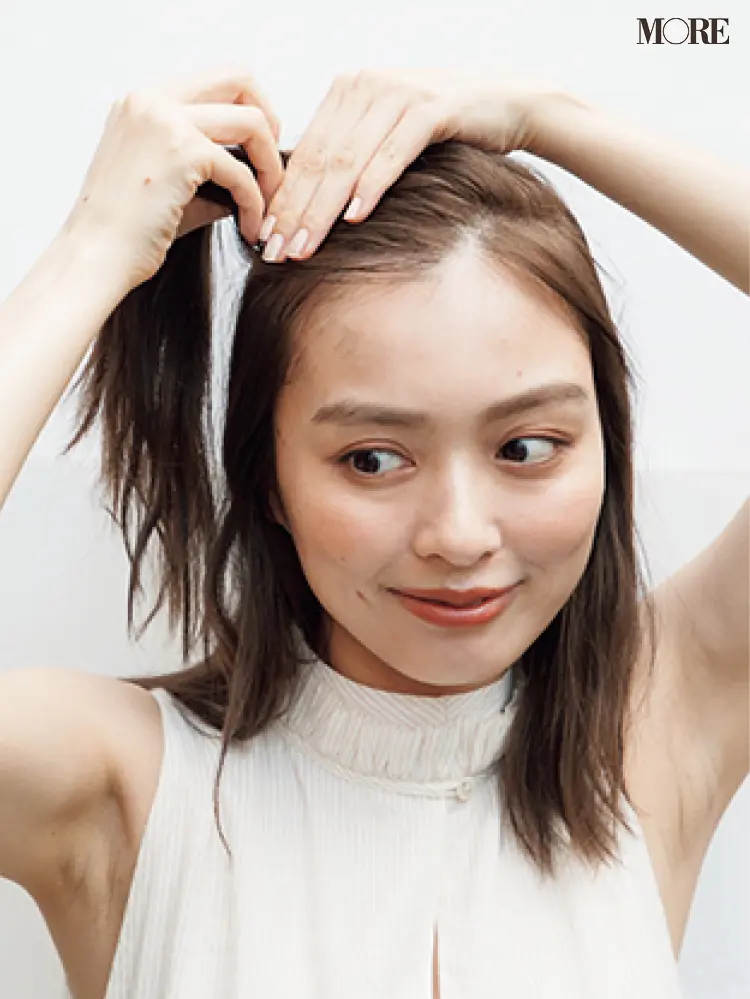 梅雨のポンパドールヘアアレンジでハチ上の髪を結ぶ女性