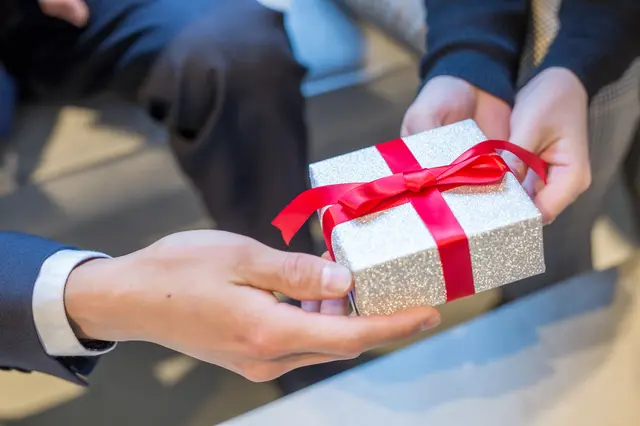 男性から女性にプレゼントを渡している手元