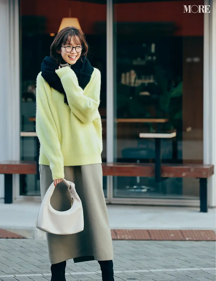 ベージュのニットワンピにイエローニットを重ねてメガネをかけた佐藤栞里
