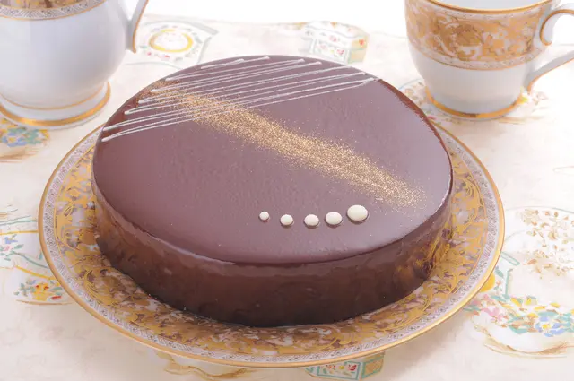 ホールのチョコレートケーキとティーカップ