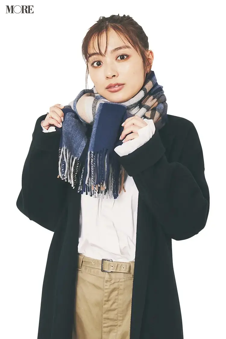 ストールの結び目を少し横にずらす女性