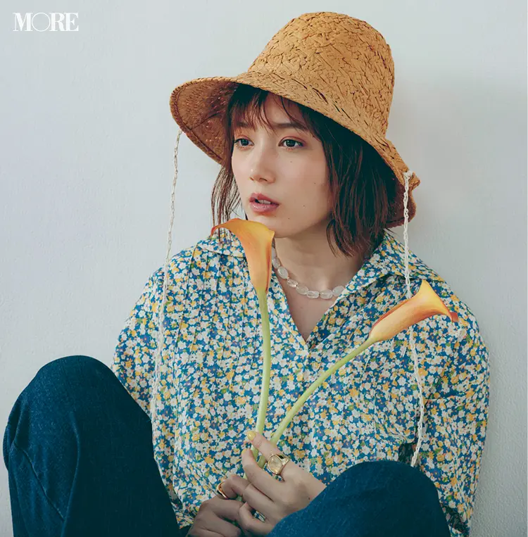 本田翼のオフショット。ハットをかぶり、座って壁に寄り掛かっている様子。