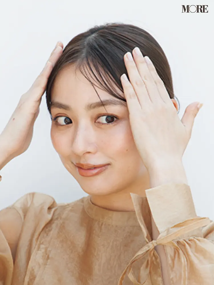 梅雨のポーニーテールヘアアレンジでワックスを髪につける女性