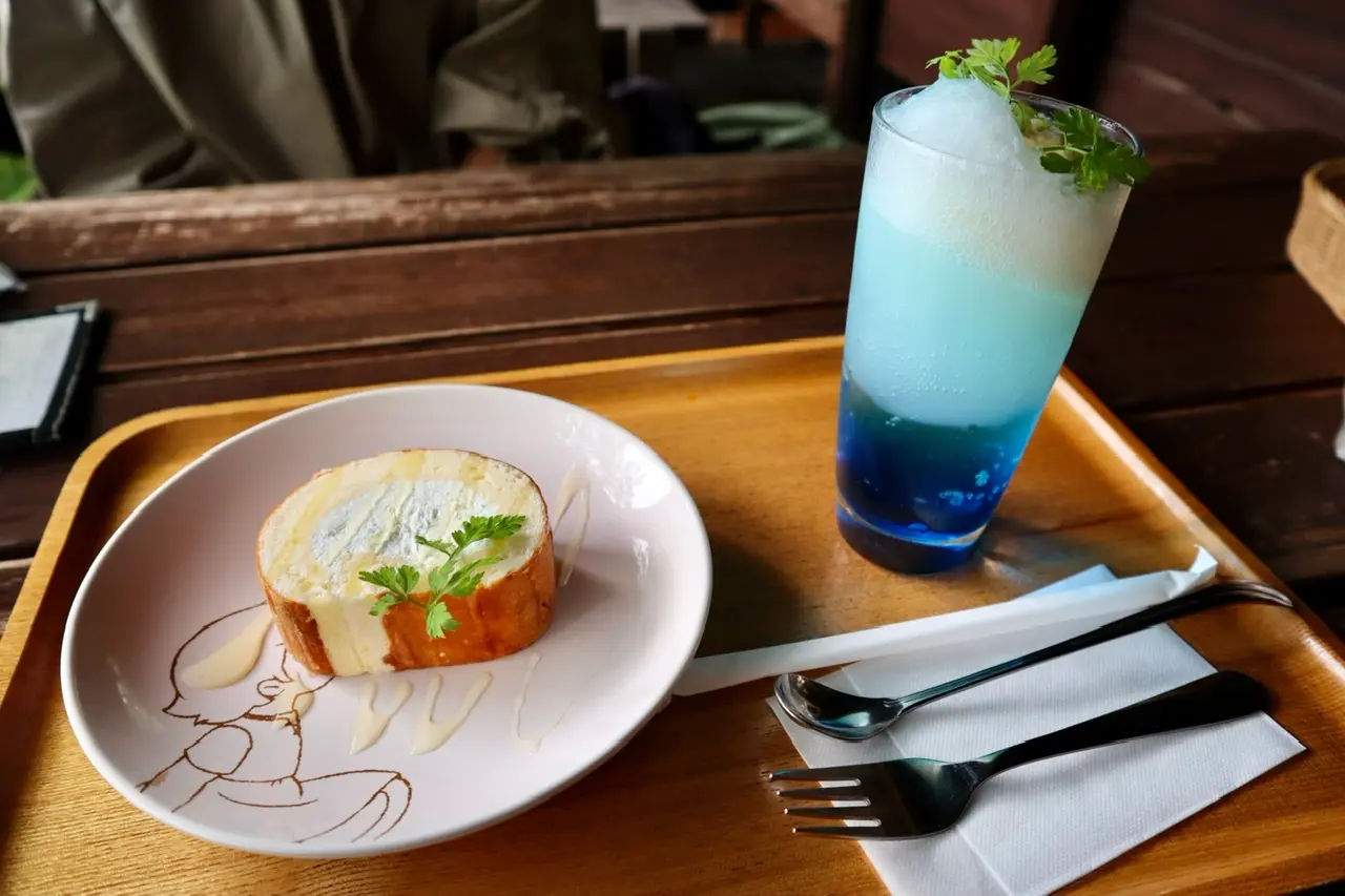 先程のクリームソーダとロールケーキを上から撮影した写真。ロールケーキは、「アルプスの少女ハイジ」が描かれた皿の上にある