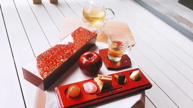 津軽塗りのお菓子箱の中に並ぶりんごスイーツたちの写真