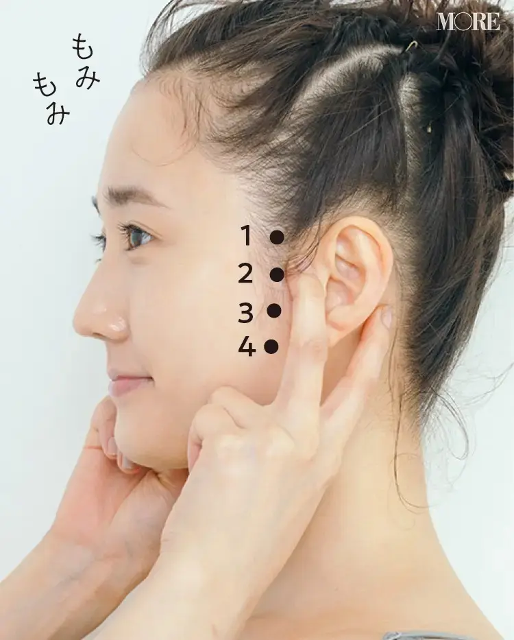 指で下から耳をはさんでもむ